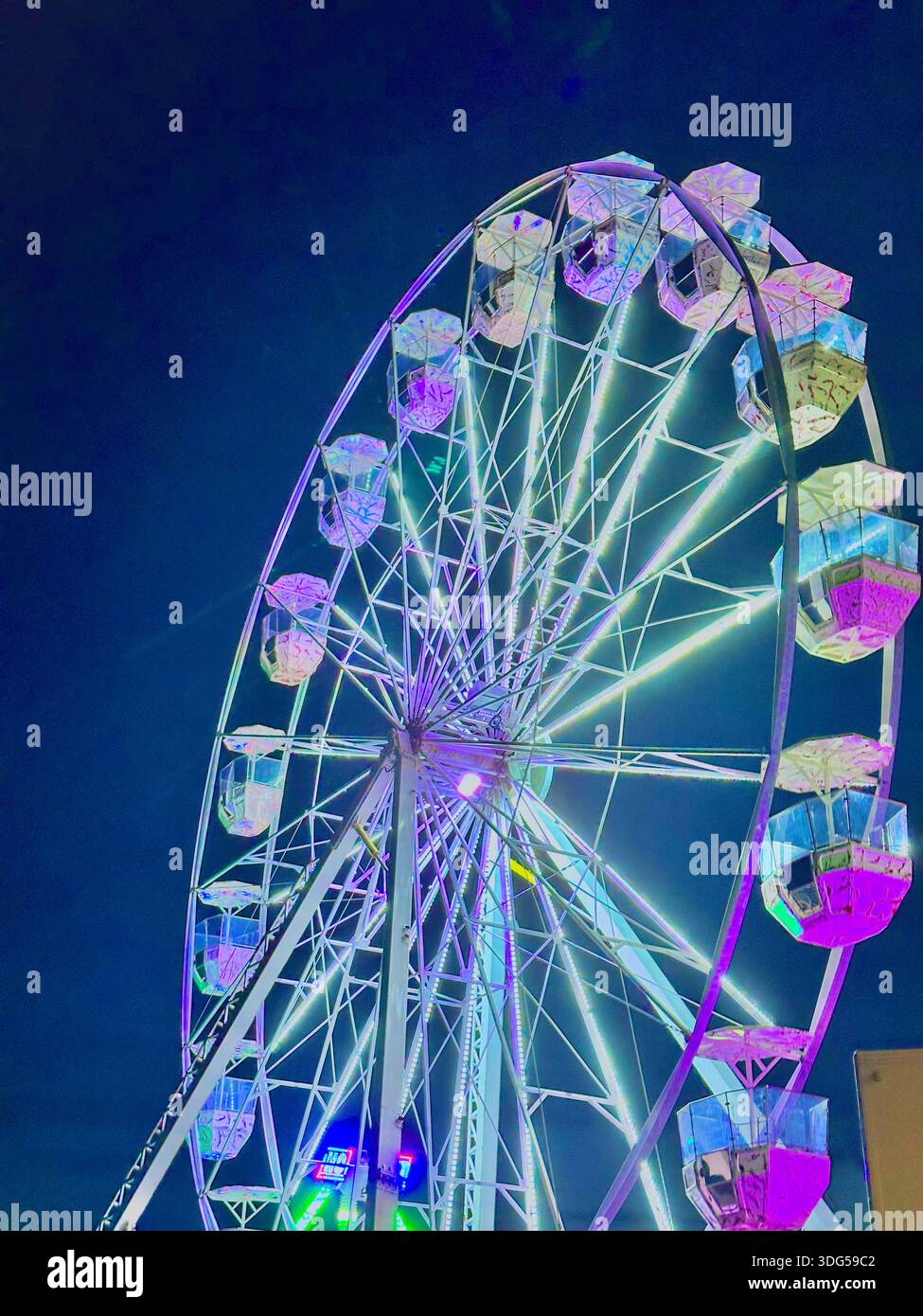 Illuminated ferris wheel at night with colorful lights against dark sky, amusement park, no peopleда - Smartphone Captured Stock Image