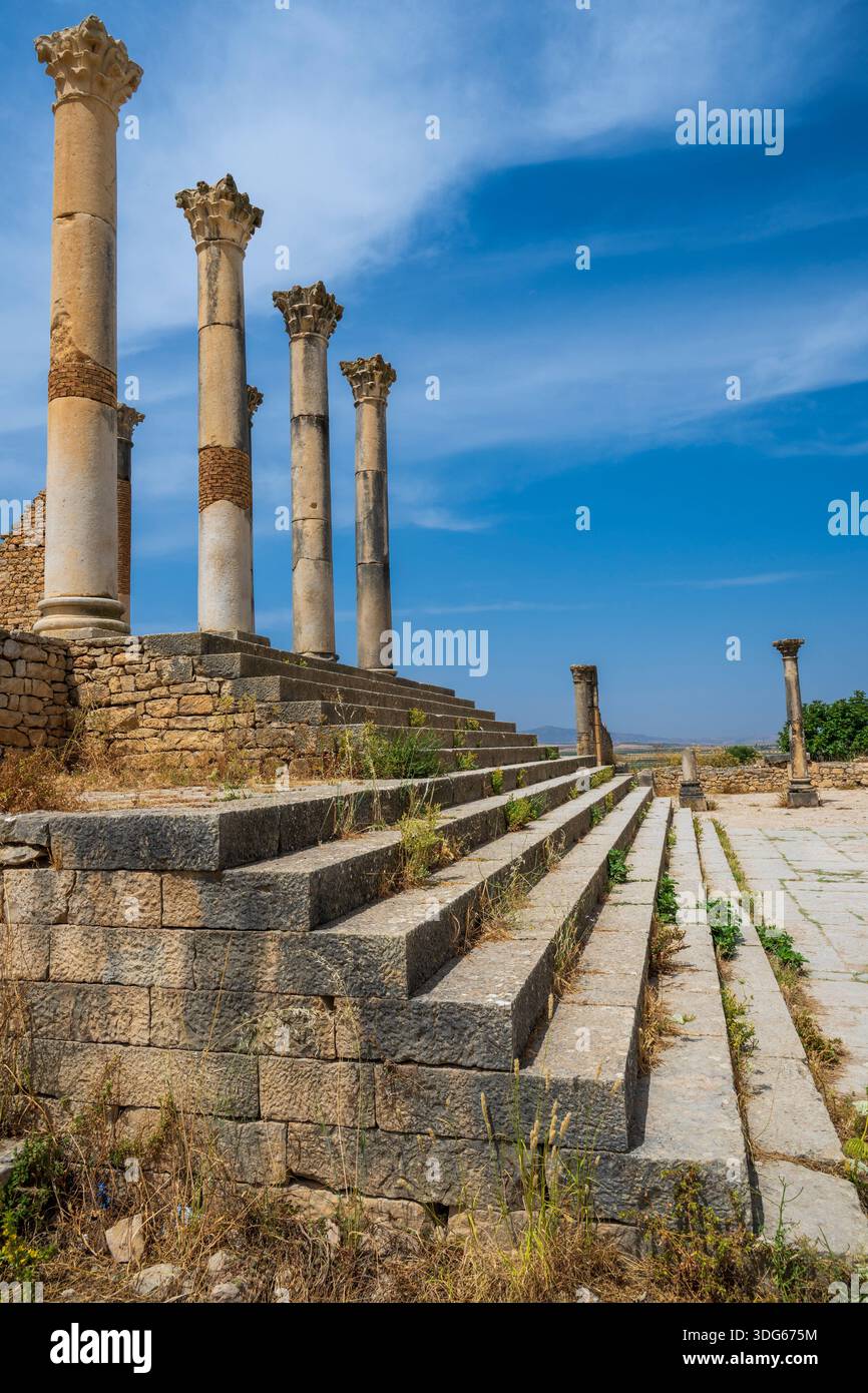 Ancient Roman columns stand tall under a clear blue sky with stone ...