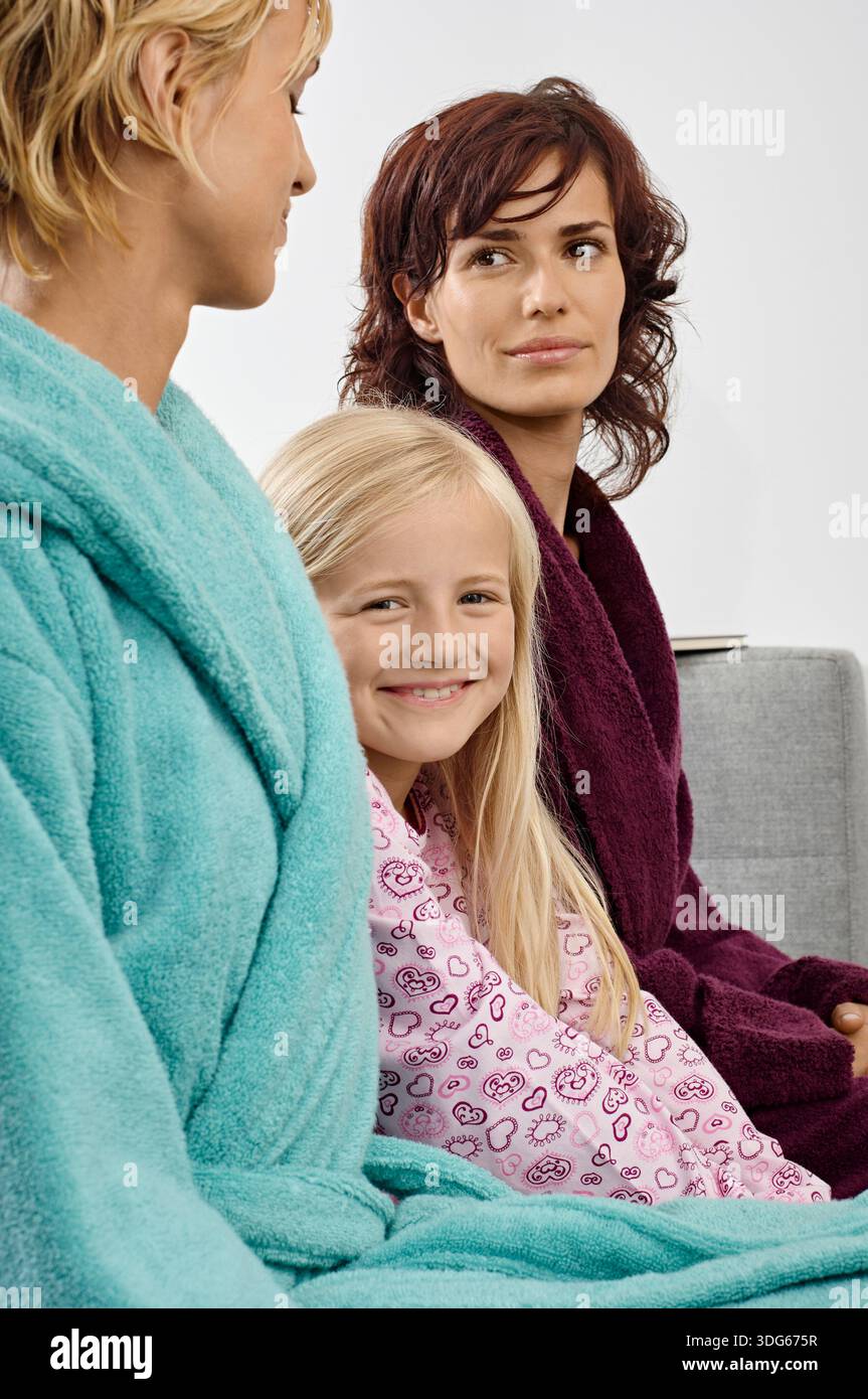 Sitting Robe Three people in colorful robes sitting on a couch, smiling and engaging ...