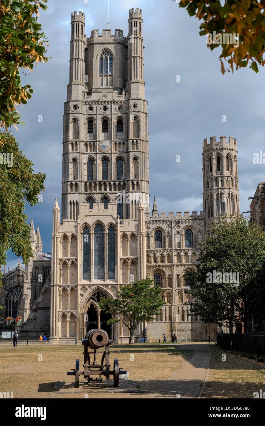 Historic cathedral with stone towers, surrounded by trees and a cannon ...