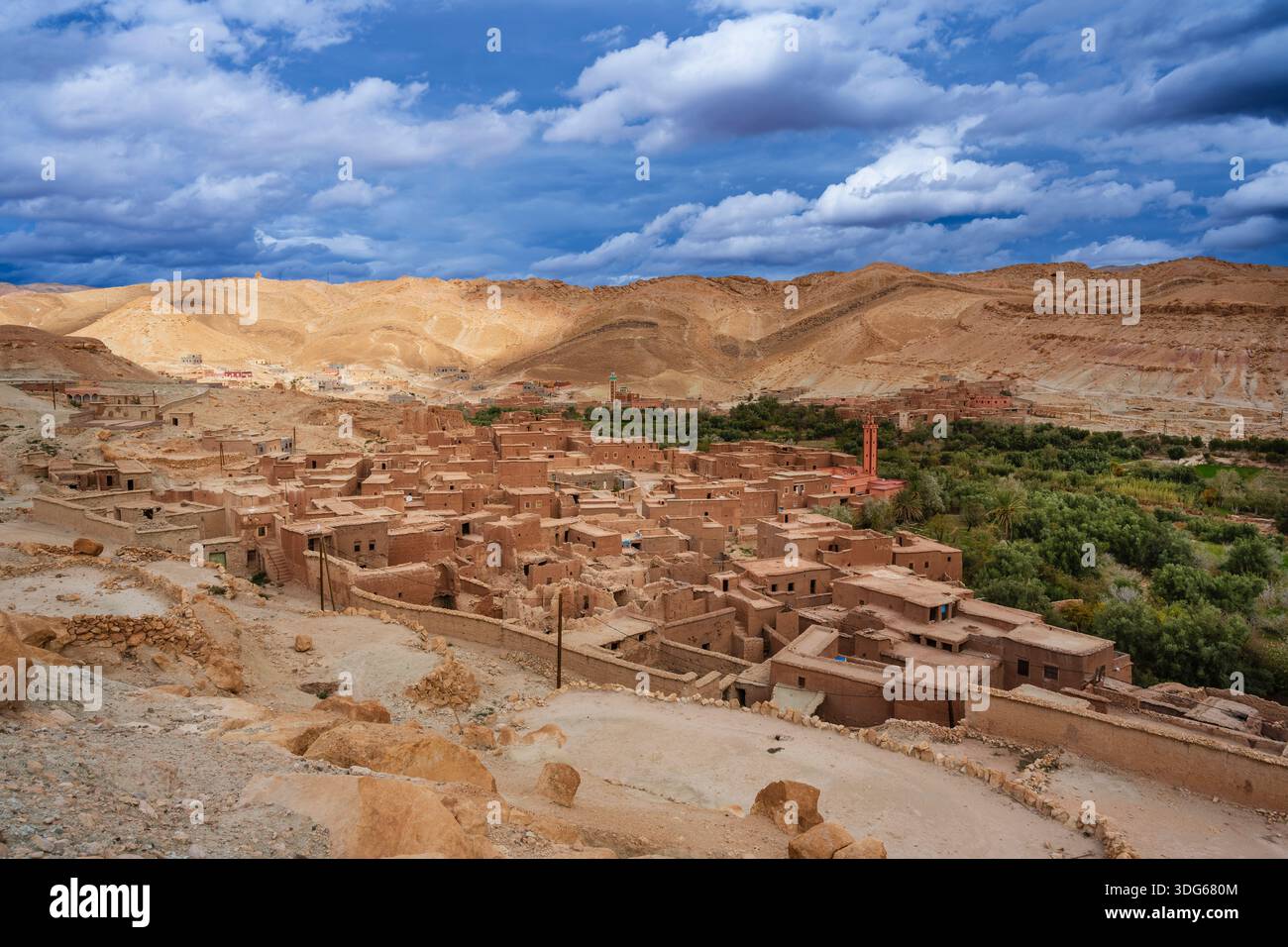 Ancient desert village with adobe houses and lush greenery under a ...