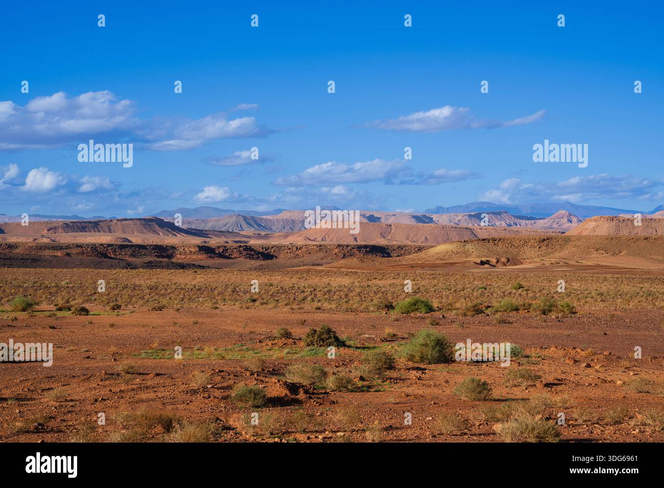 Vast desert landscape with distant mountains under a clear blue sky and ...
