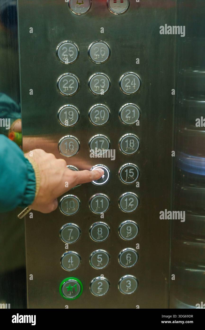 Person pressing keypad in elevator with floor display and load info ...