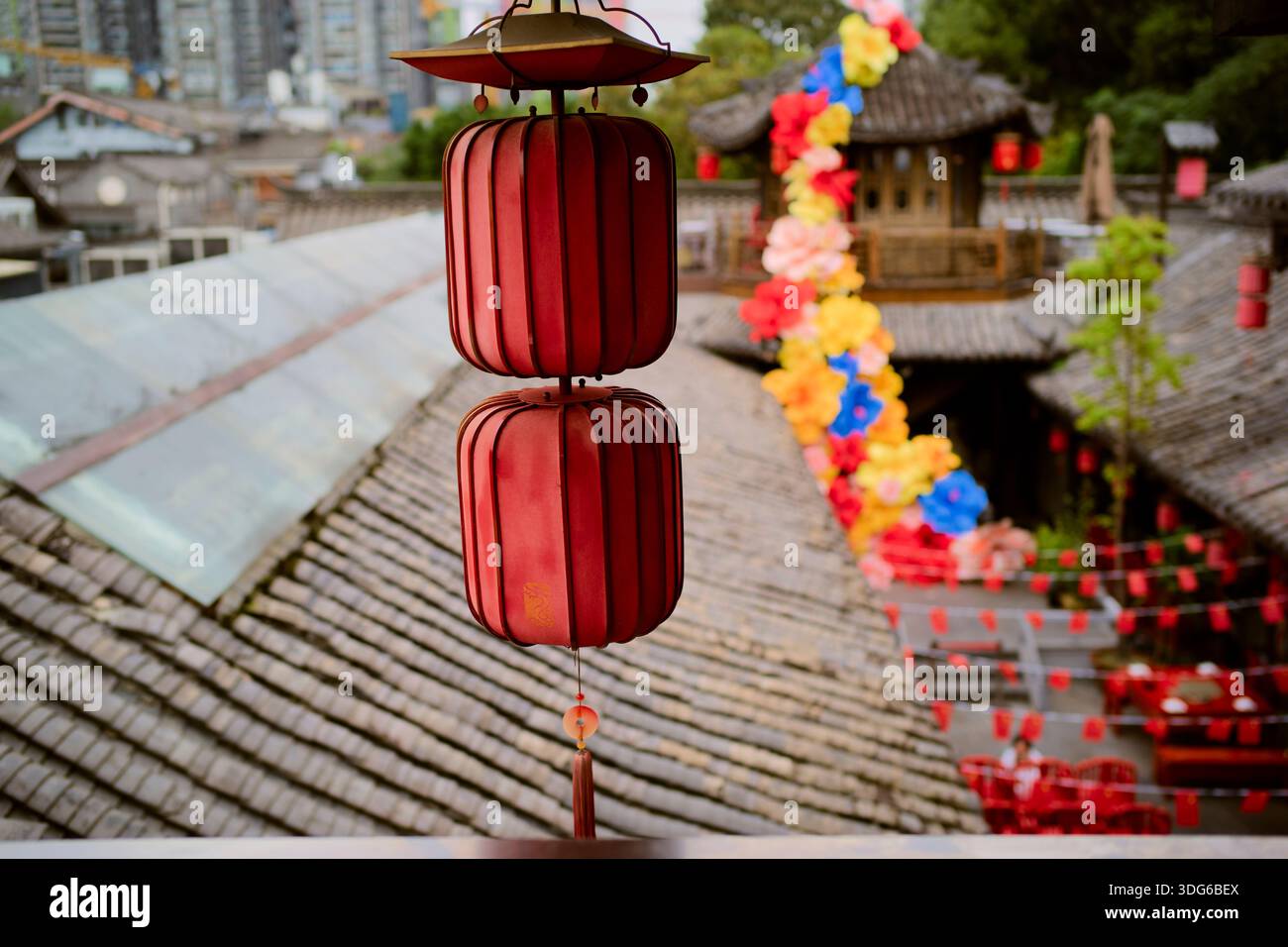 Red lanterns hanging in a traditional Asian courtyard with colorful ...