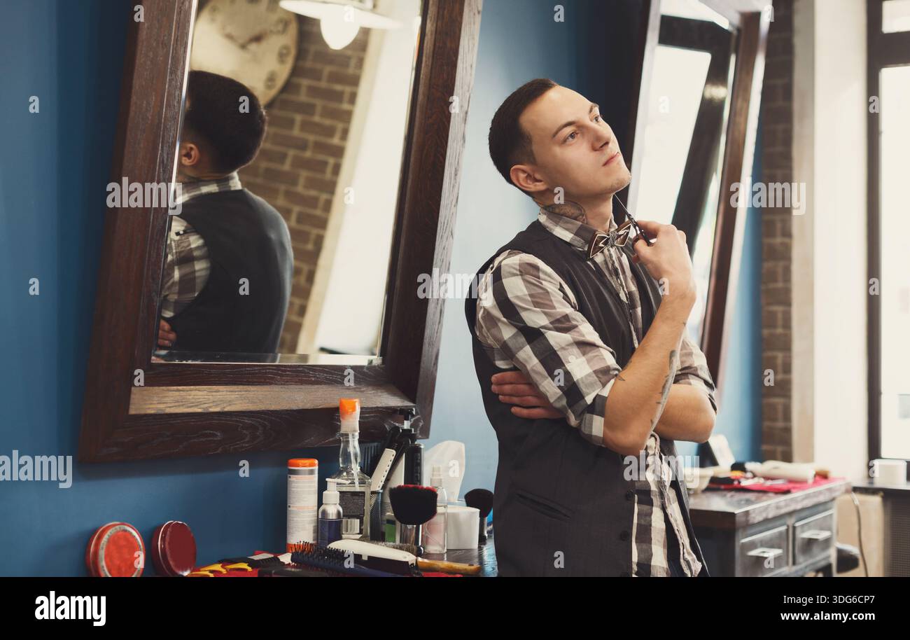 Bearded barber posing to camera at barbershop Stock Photo