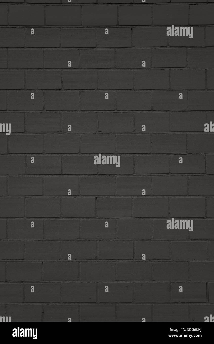 Black brick wall with uniform masonry and clean surface. Used as a structured background in visual projects. Stock Photo