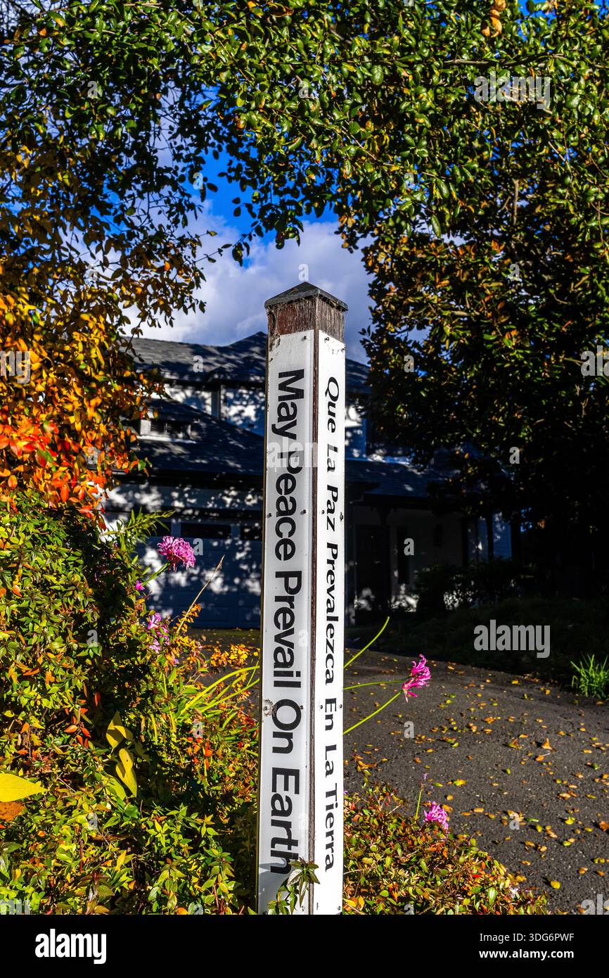 Peace Pole inscribed with the message "May Peace Prevail on Earth" in four languages, including English and Spanish Stock Photo