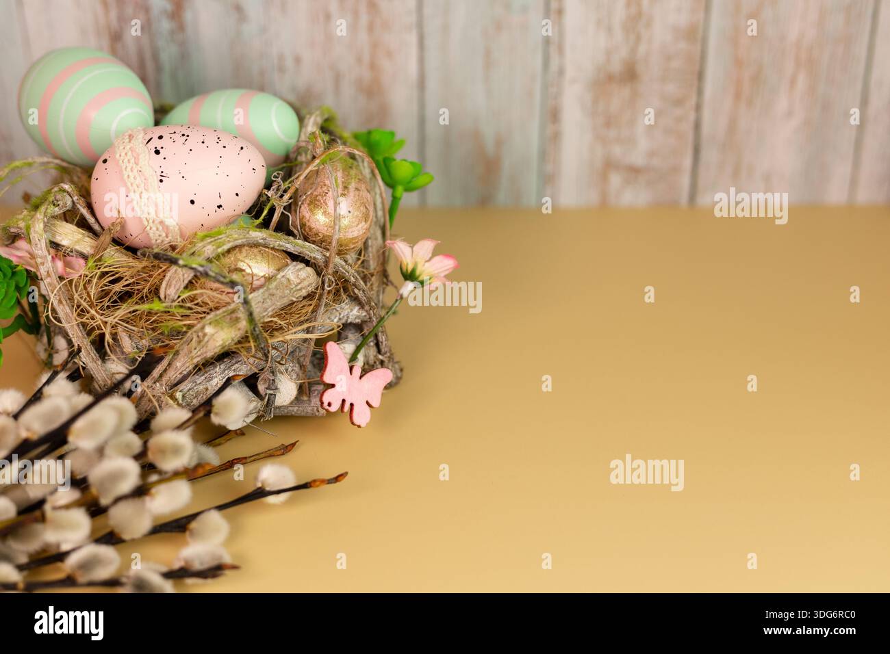 Rustic Easter composition with colorful eggs arranged in a handmade nest Stock Photo