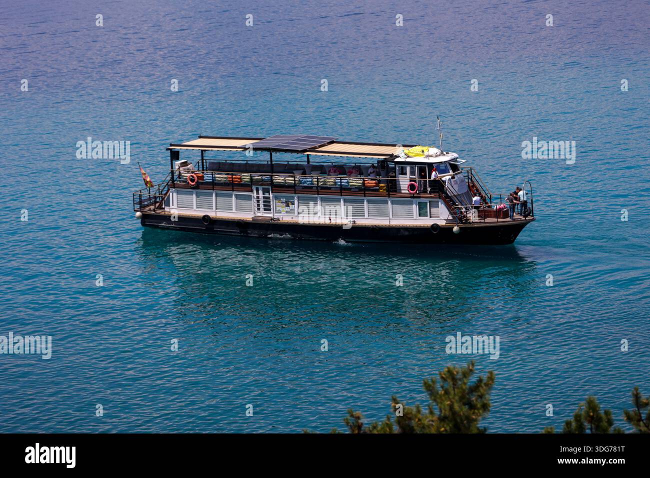 Tourist Boat Cruising on a Calm Blue Lake Stock Photo