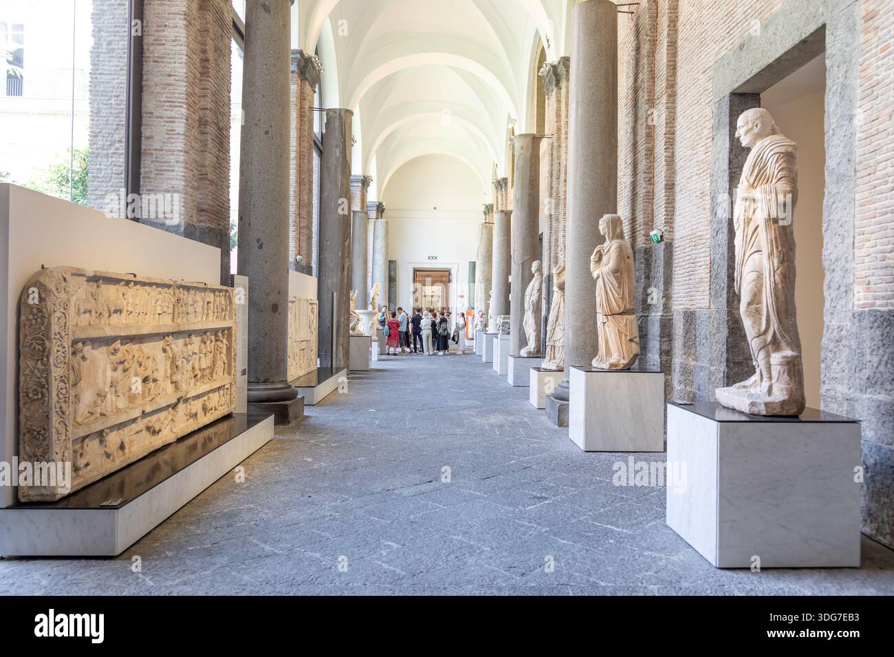 NAPLES, ITALY – AUGUST 2025: Tourists walk among ancient Roman statues ...