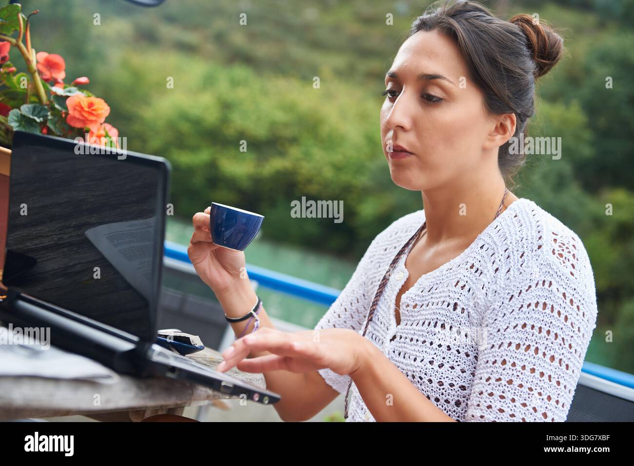 Remote working woman using laptop drinking coffee Stock Photo