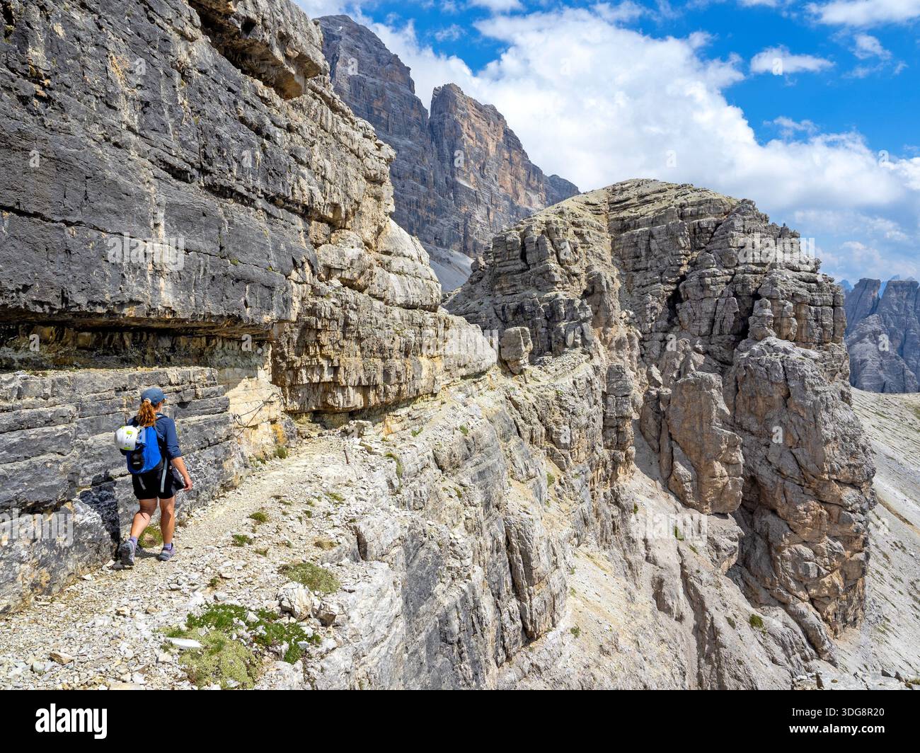 Hiker on a narrow ledge near Rifugio Pian di Cengia in the Sesto Dolomites Stock Photo