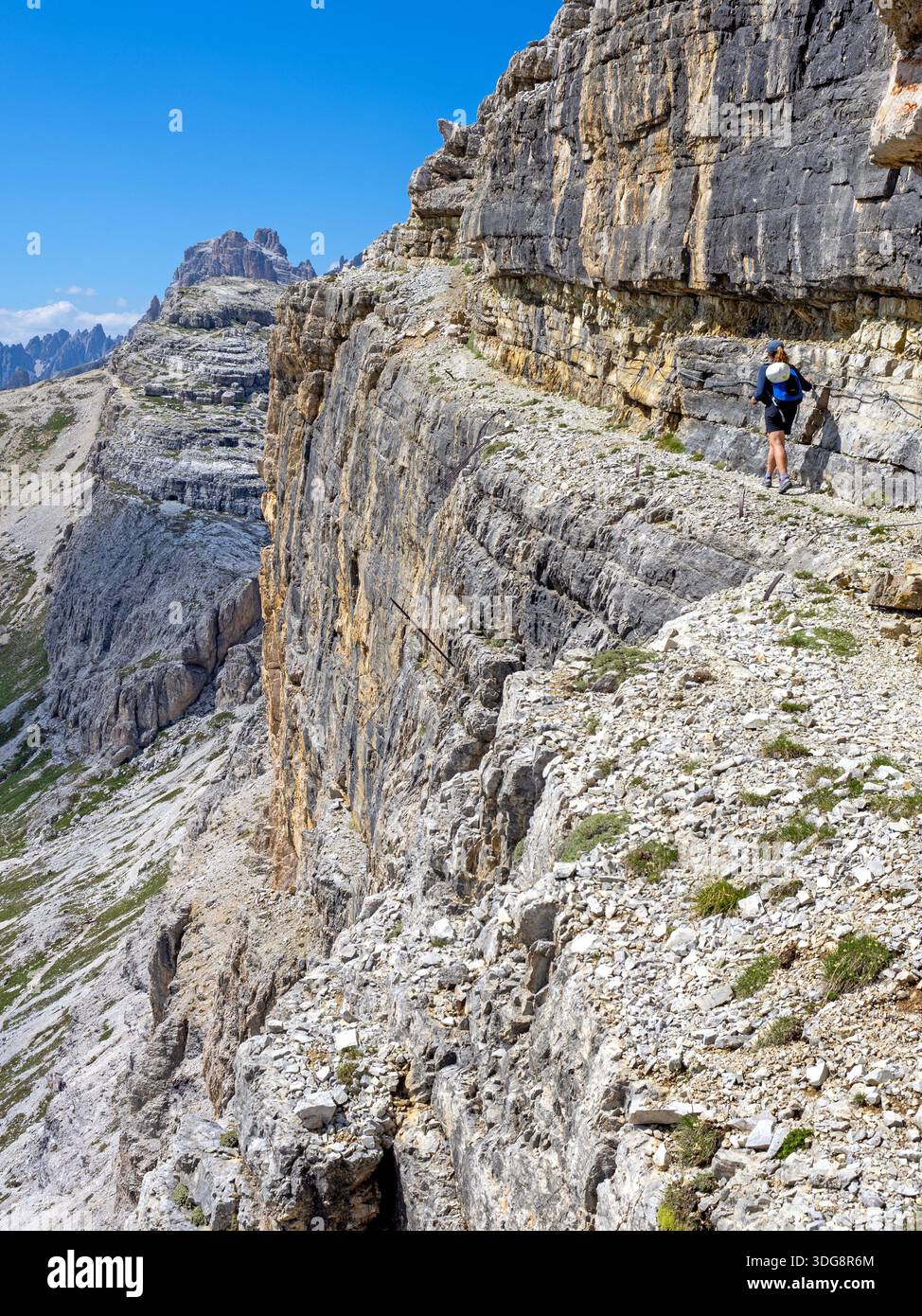 Hiker on a narrow ledge near Rifugio Pian di Cengia in the Sesto Dolomites Stock Photo