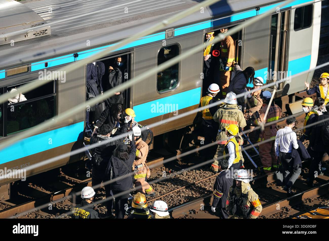 Passengers get off a train with the help of railway company personnel ...