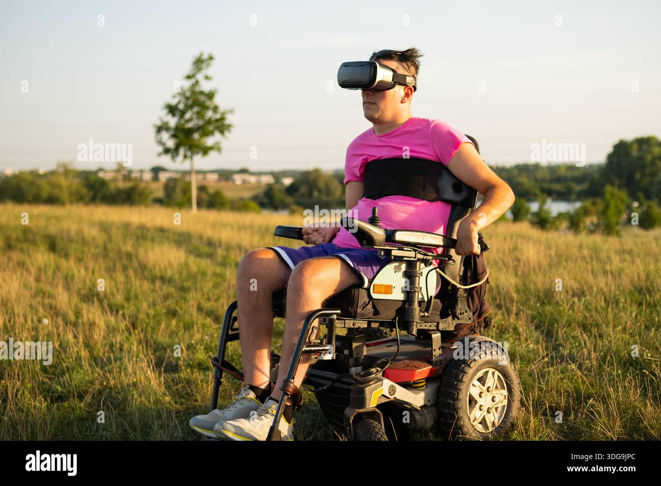 Modern assistive technology and entertainment concept featuring a man using VR headset under sunlight. Stock Photo
