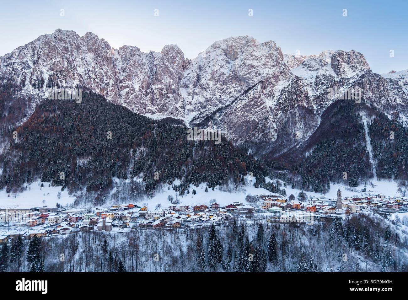 Aerial view of Colere town with view of the north face of the Presolana mountain in winter after a snowfall. Colere, Val di Scalve, Bergamo district. Stock Photo