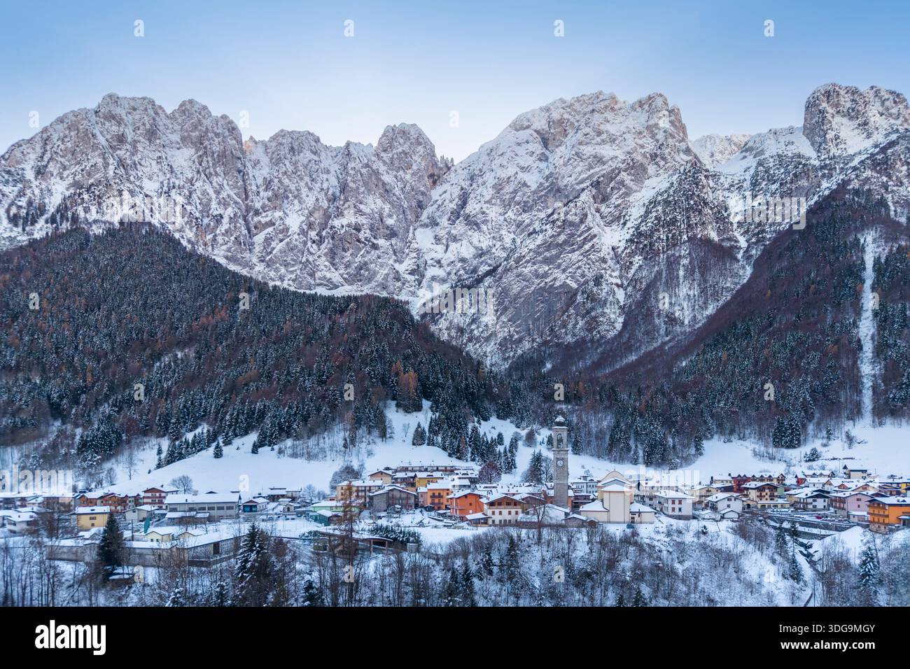 Aerial view of Colere town with view of the north face of the Presolana mountain in winter after a snowfall. Colere, Val di Scalve, Bergamo district. Stock Photo