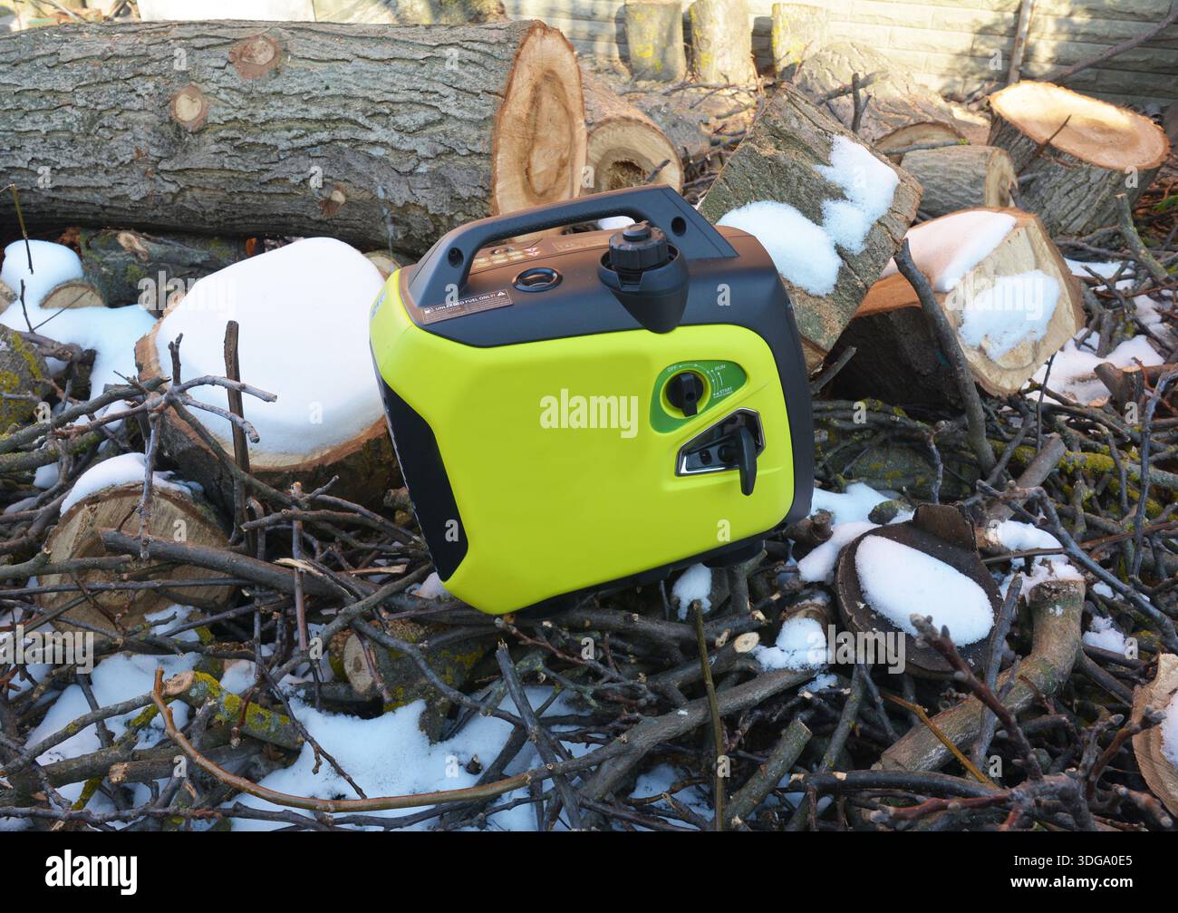 Portable Inverter Generator Outdoors Near Firewood in Winter Stock Photo