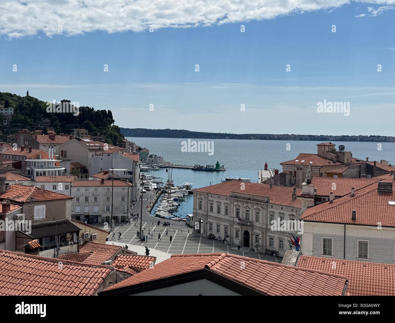 Scenic view of Piran, Slovenia — red rooftops, marina, and historic waterfront under a partly cloudy sky - Smartphone Captured Stock Image