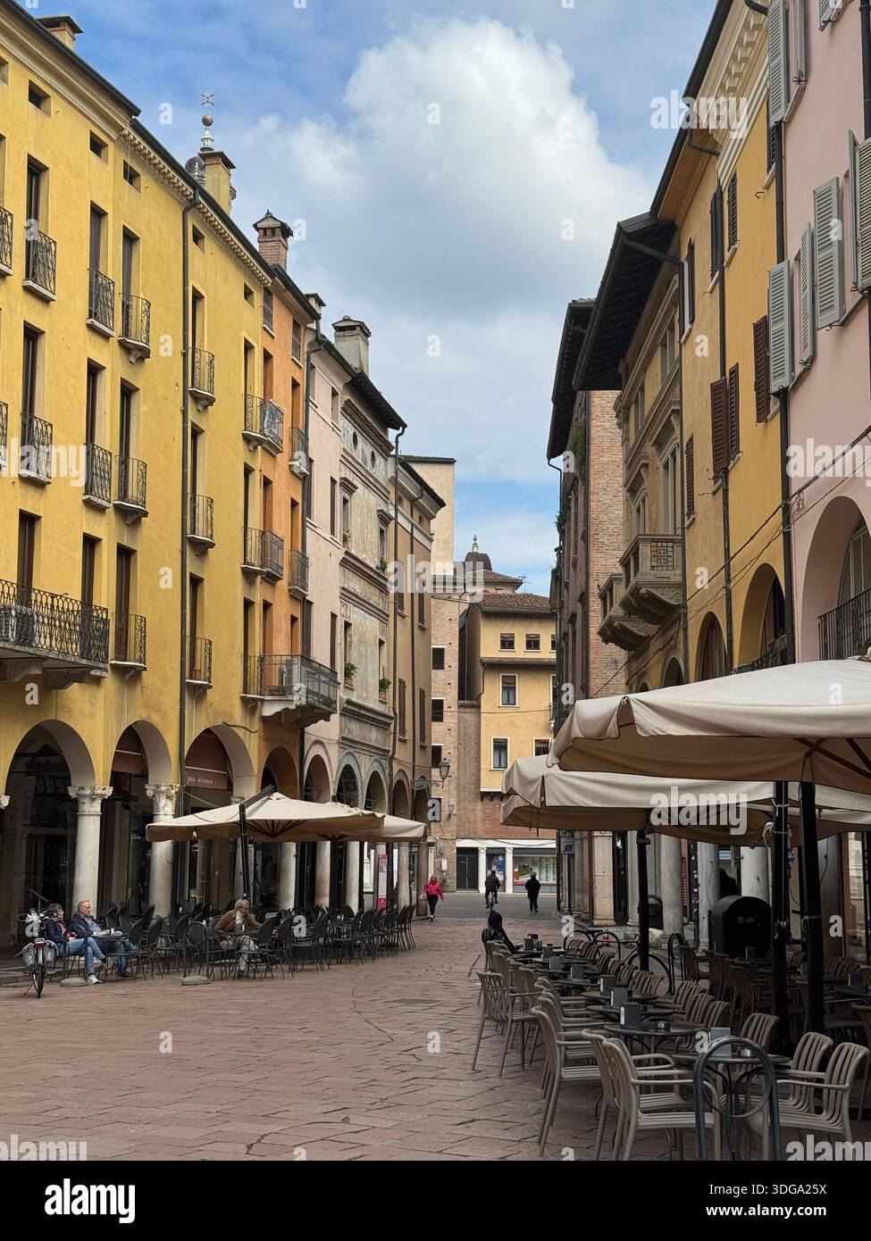 Charming street scene in Mantua, Italy, with porticos, balconies, and outdoor cafés in warm tones - Smartphone Captured Stock Image