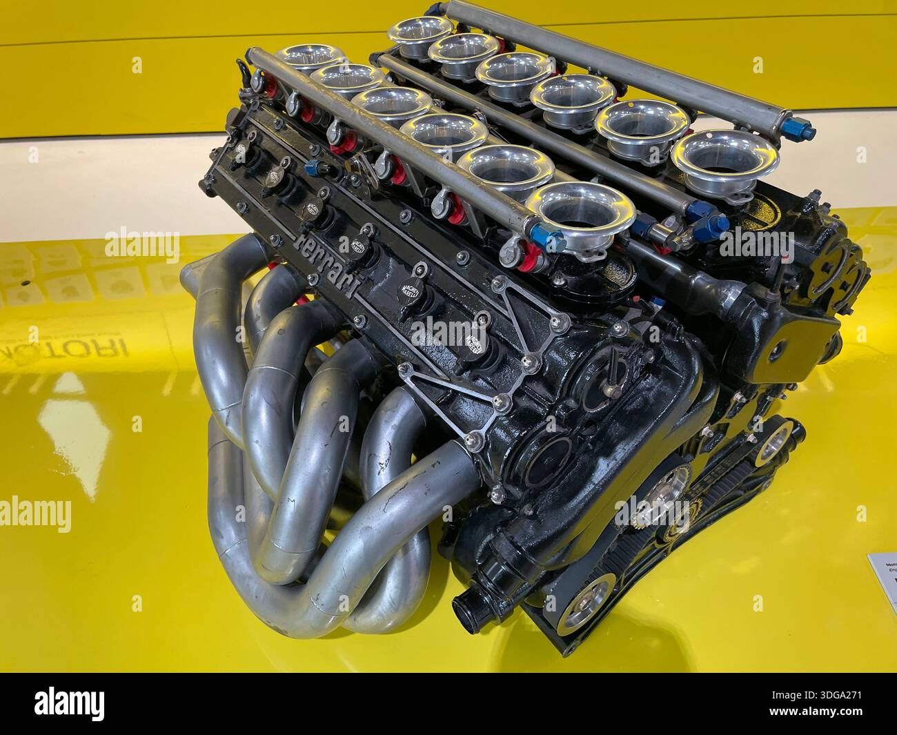 Historic Ferrari racing engine on display at the Ferrari Museum in Modena, Italy, showcasing Italian automotive engineering and motorsport heritage - Smartphone Captured Stock Image