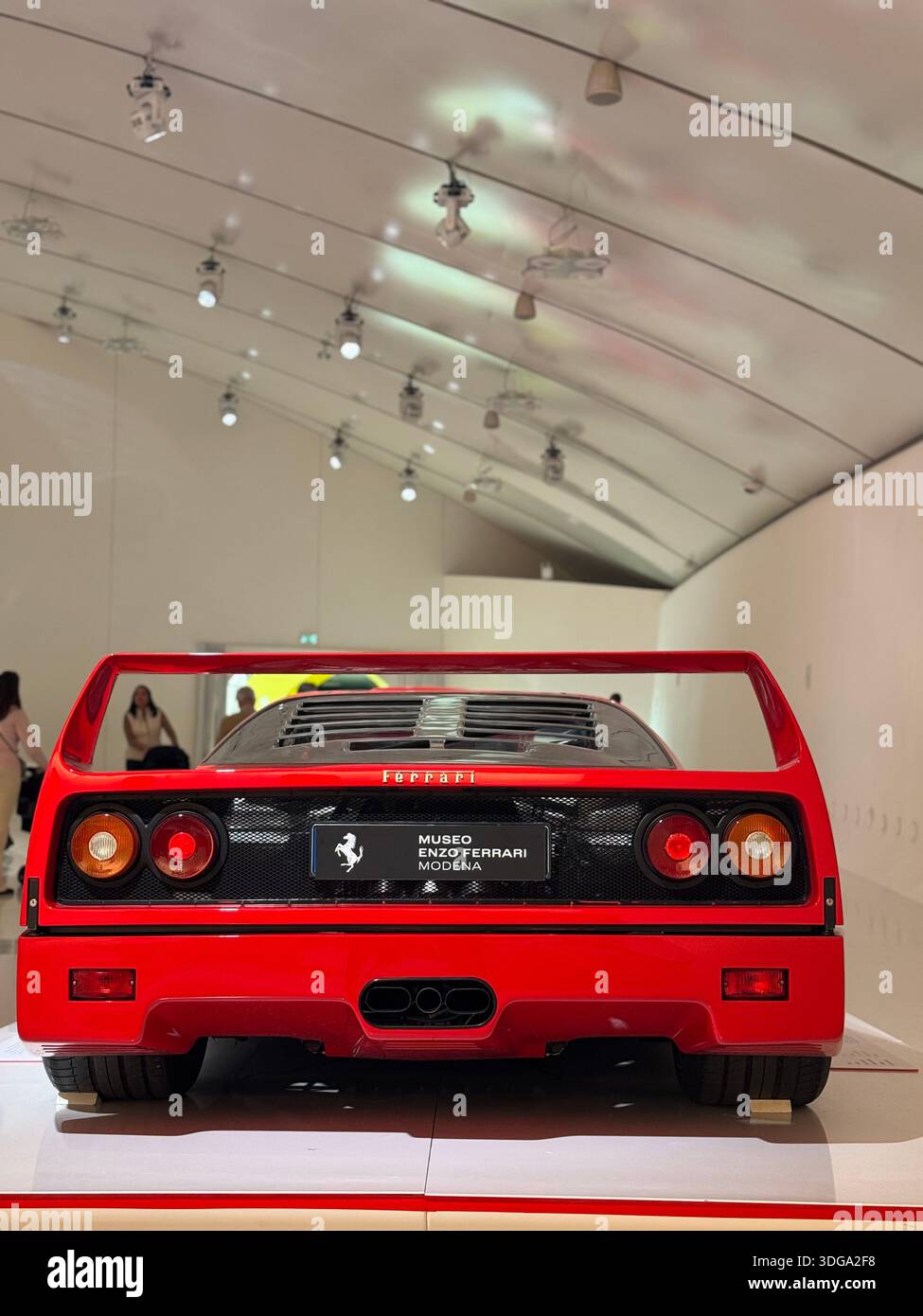 Close-up detail of a red Ferrari sports car with the iconic prancing horse badge on display at the Ferrari Museum in Modena, Italy - Smartphone Captured Stock Image