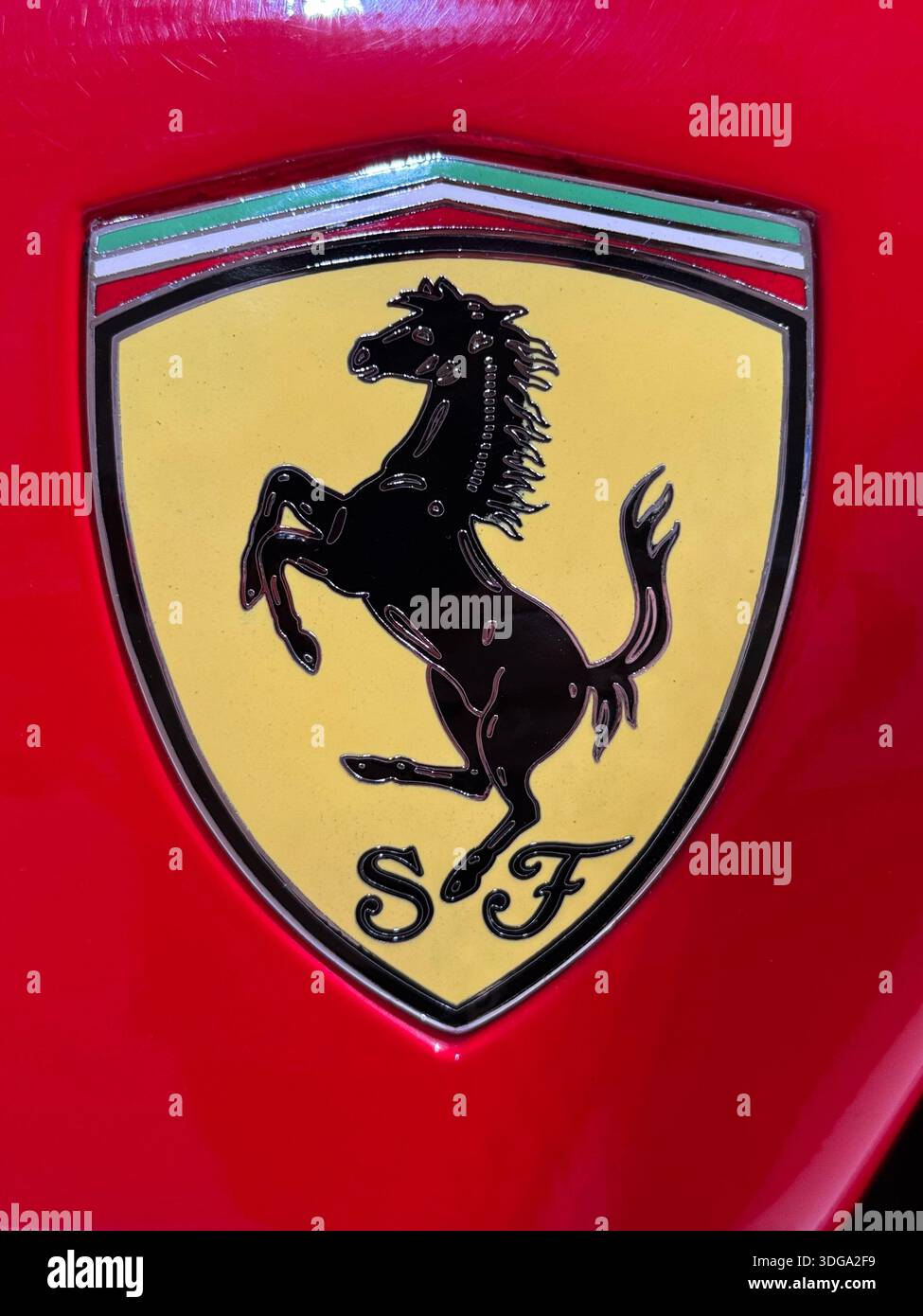 Close-up detail of a red Ferrari sports car with the iconic prancing horse badge on display at the Ferrari Museum in Modena, Italy - Smartphone Captured Stock Image
