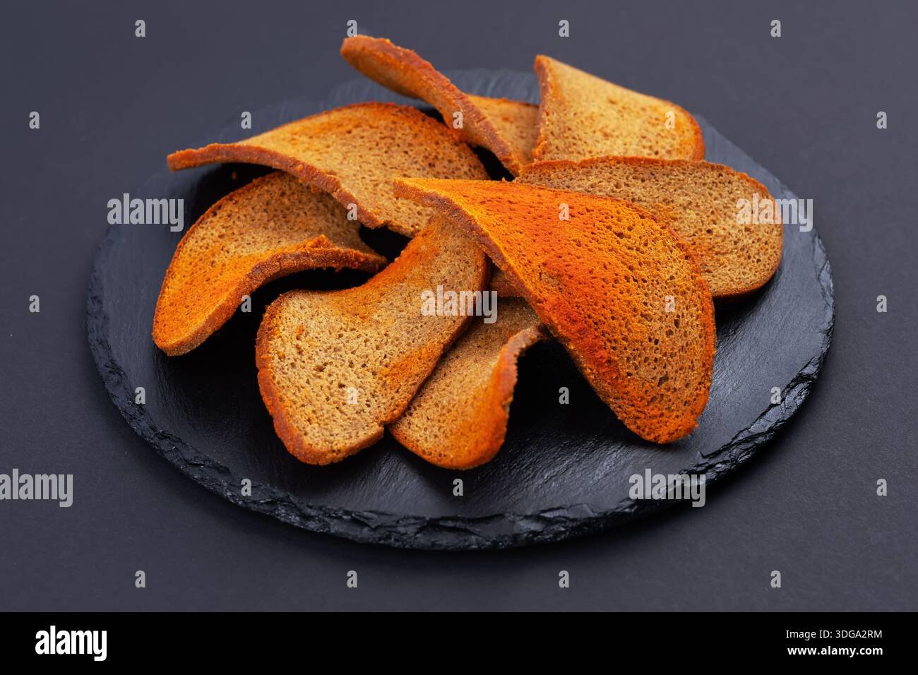 Rye bread crackers in spices on dark background, Beer snack, Stock Photo