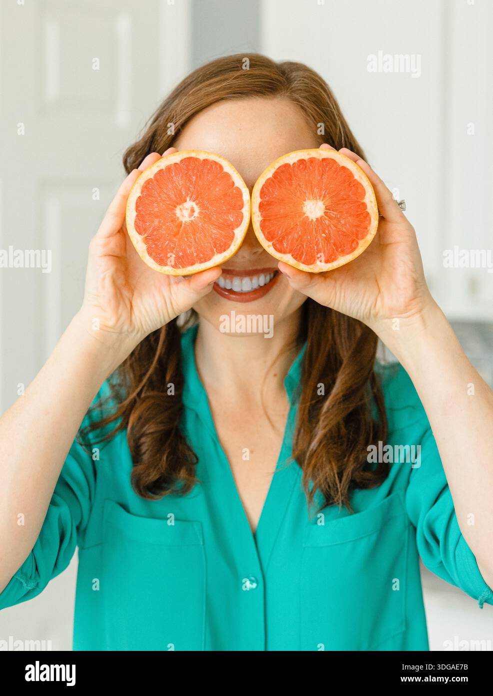 Beautiful Woman Holding Ruby Red Grapefruit Cut in Half Stock Photo