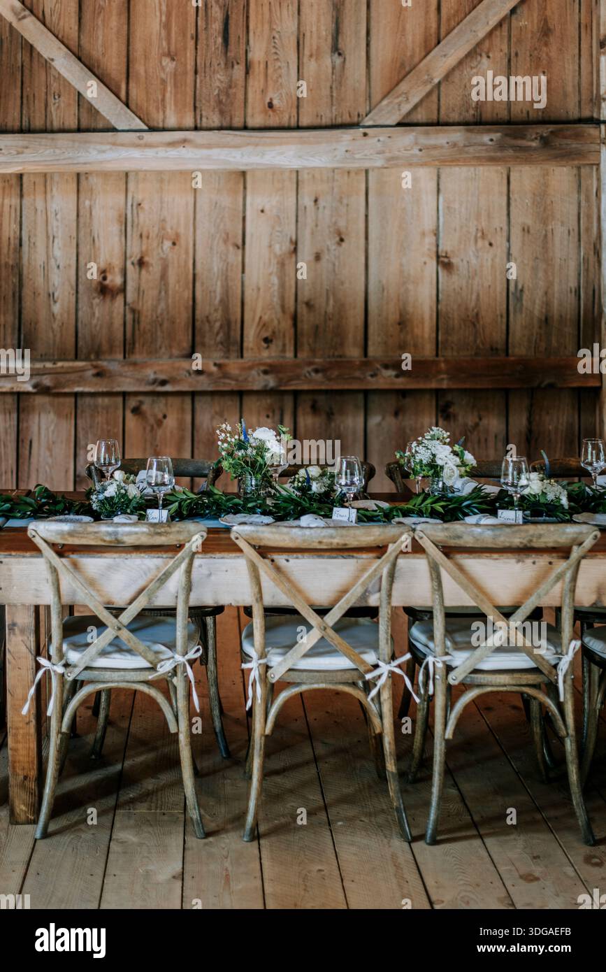 Formal table setting with flowers in a rustic barn, rehearsal dinner Stock Photo