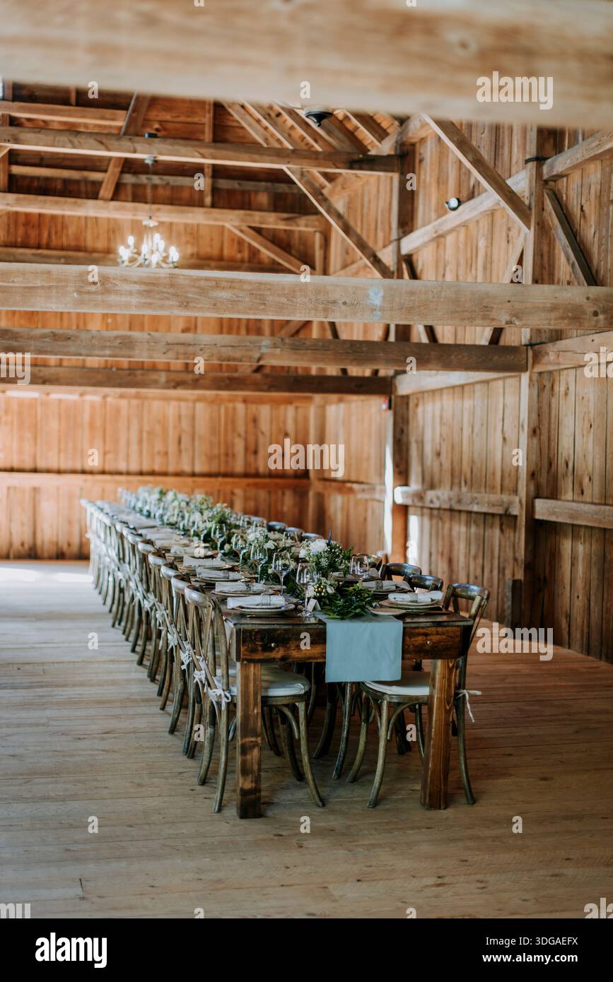 Formal table setting for rehearsal dinner in rustic barn setting Stock Photo