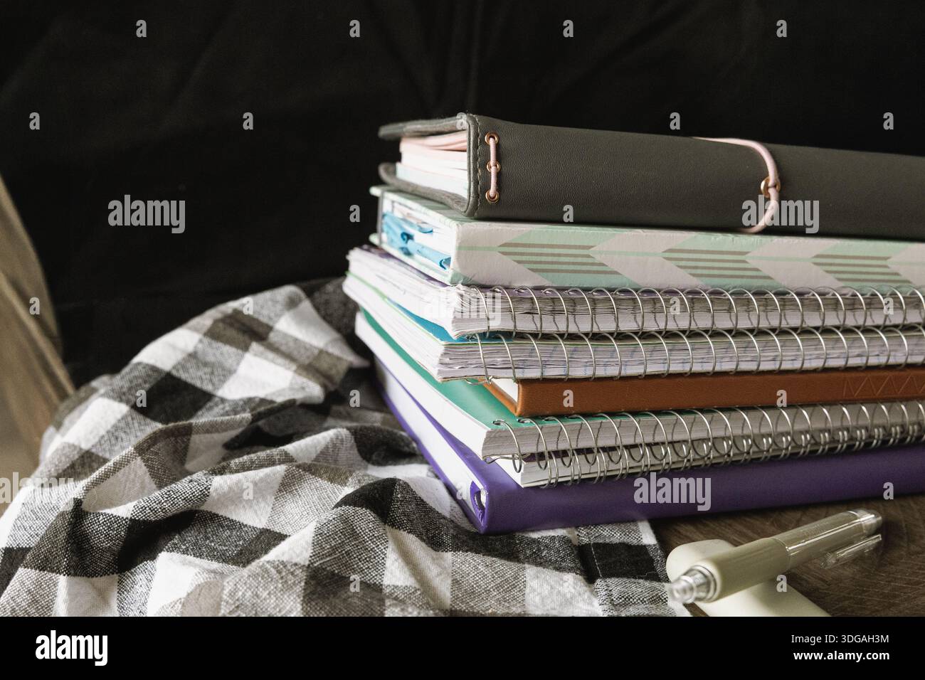 Ready to Create: A Stack of Notebooks and Pens for Endless Ideas Stock Photo
