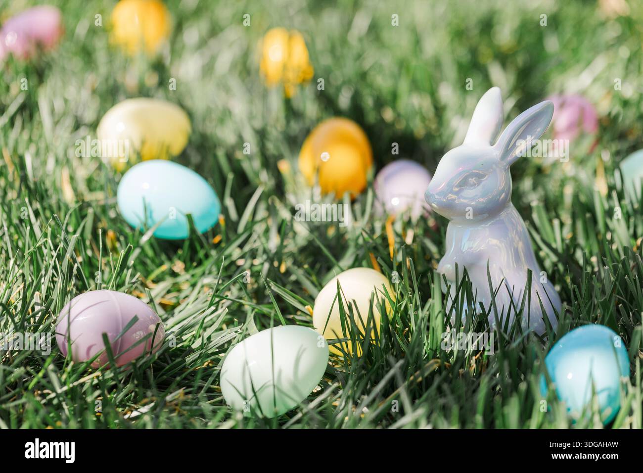 Easter eggs and ceramic Easter bunny in green grass. Stock Photo