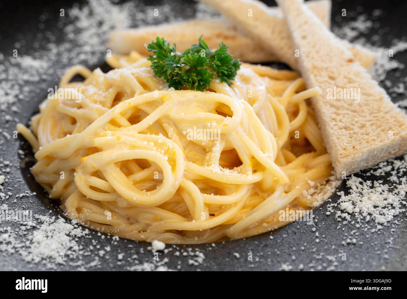 30 December 2025: A plate of spaghetti with creamy cheese sauce, garnished with parsley and served with toast *** Ein Teller Spaghetti mit cremiger Käsesoße, garniert mit Petersilie und serviert mit Toastbrot