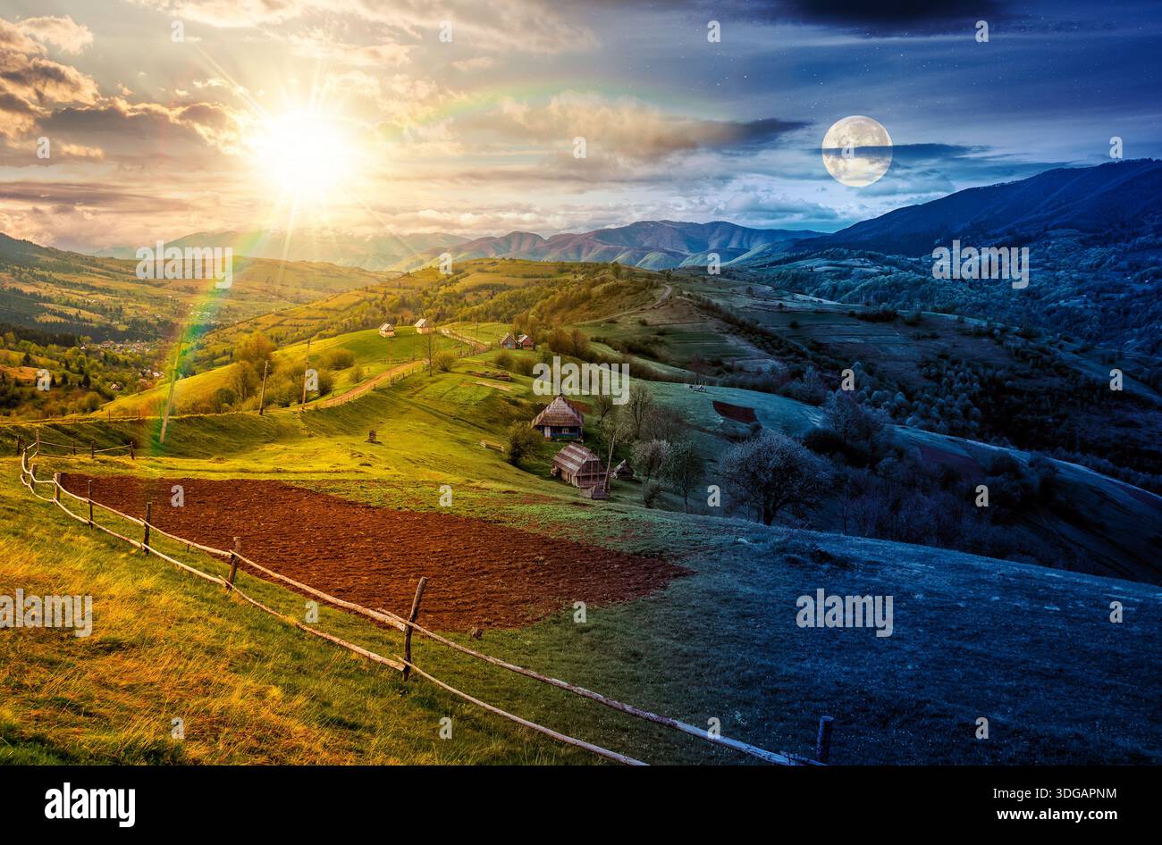 scenic view of arable and wooden fence on hills in rural area. day and night time change concept. beautiful countryside mountain landscape in spring w Stock Photo