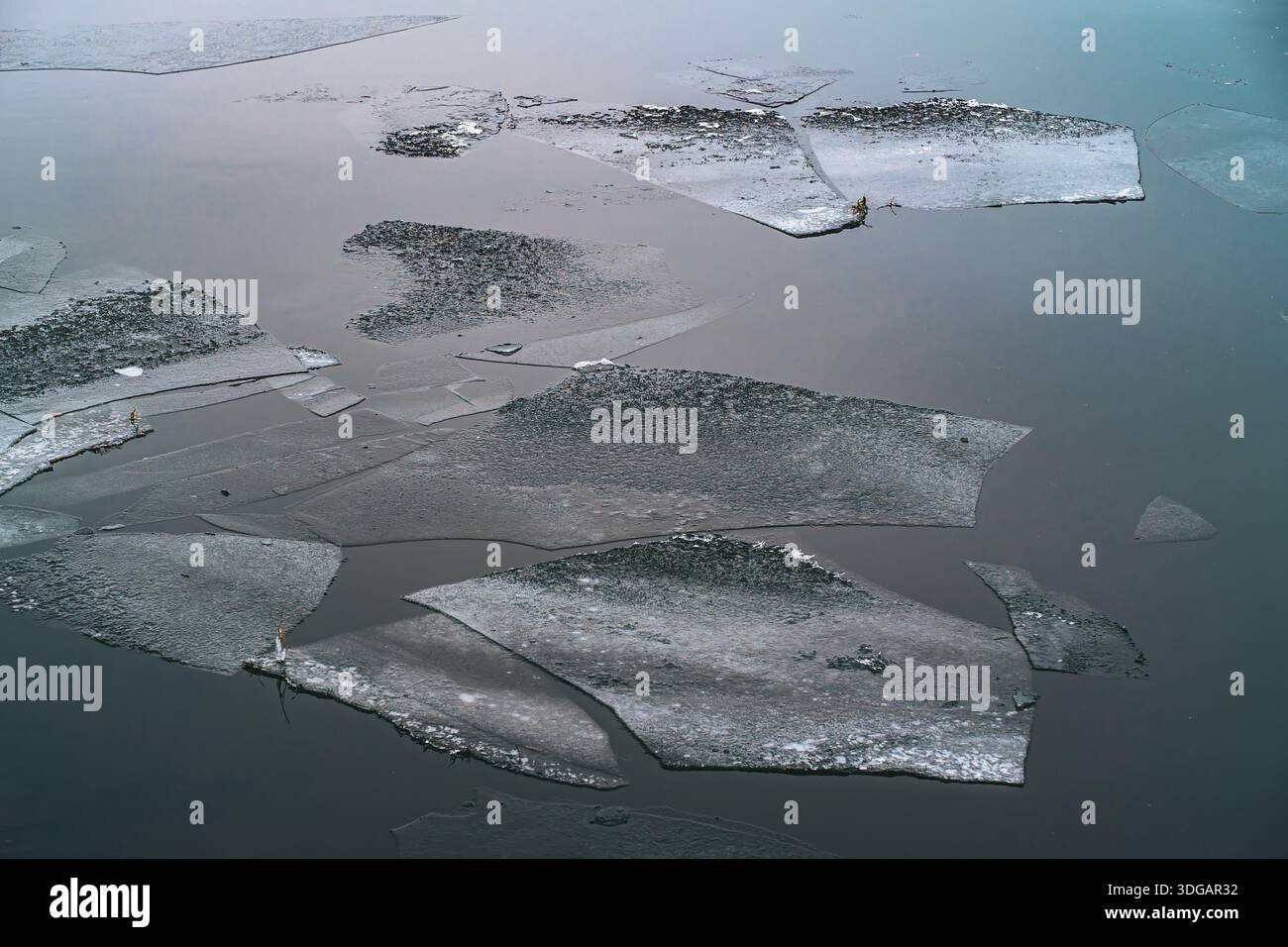 Broken Ice Sheets Floating on Calm Water Surface in Winter Stock Photo