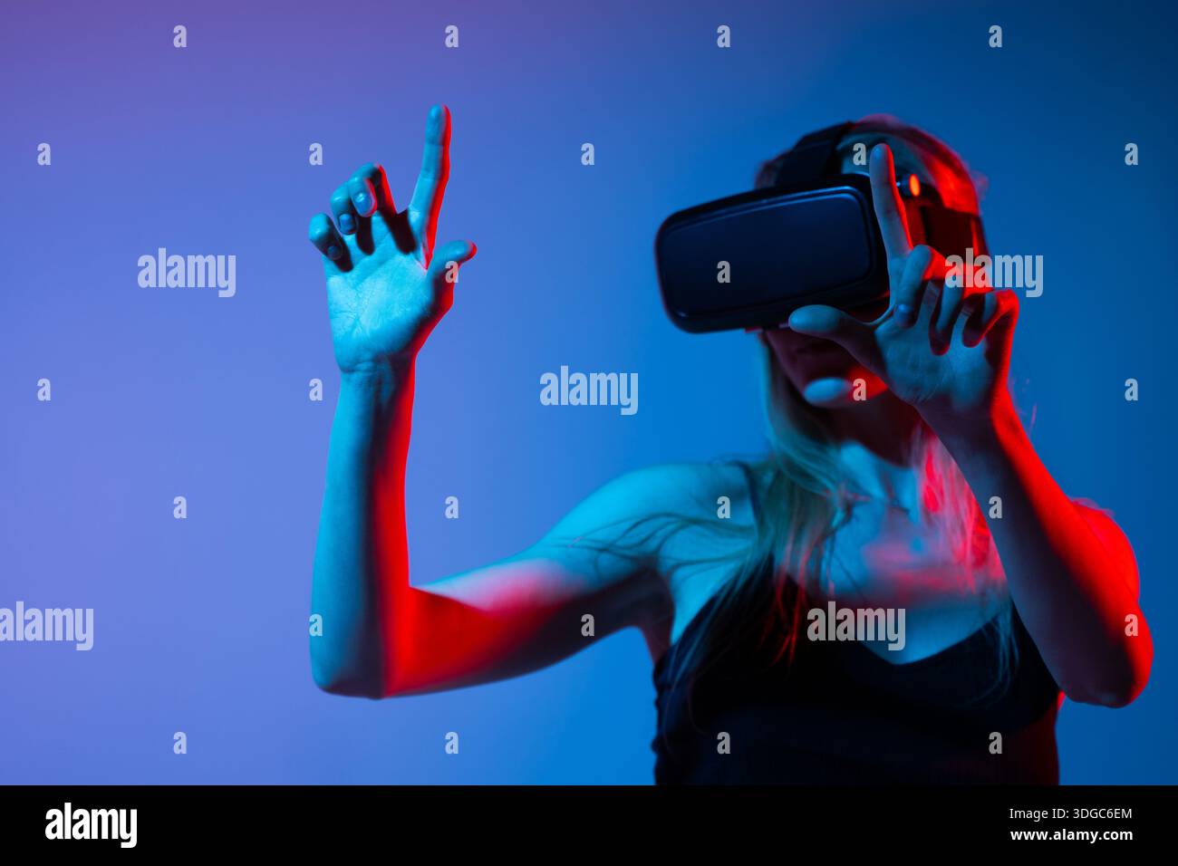 Virtual reality interaction with woman using hand gestures, immersive digital interface and metaverse technology experience Stock Photo