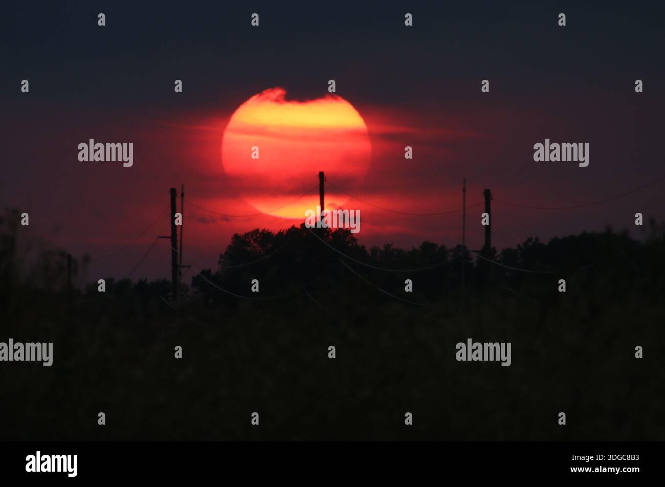 Red Sunset through Clouds and Power Lines, Central Minnesota Stock Photo