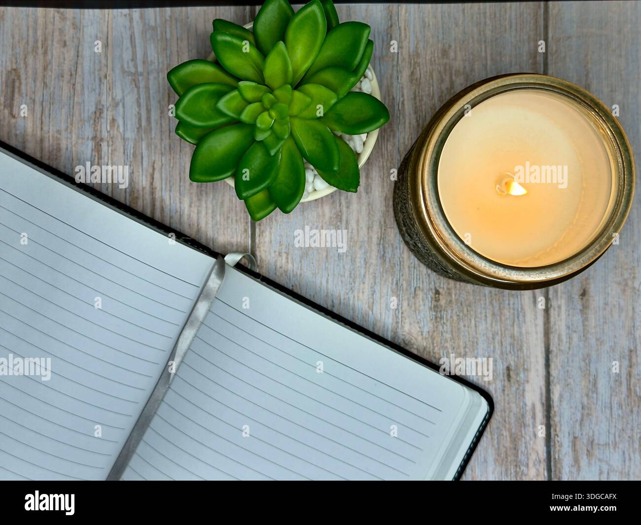 Calming Self Care Scene With Candle, Journal, and Plant on Wooden Surface - Smartphone Captured Stock Image