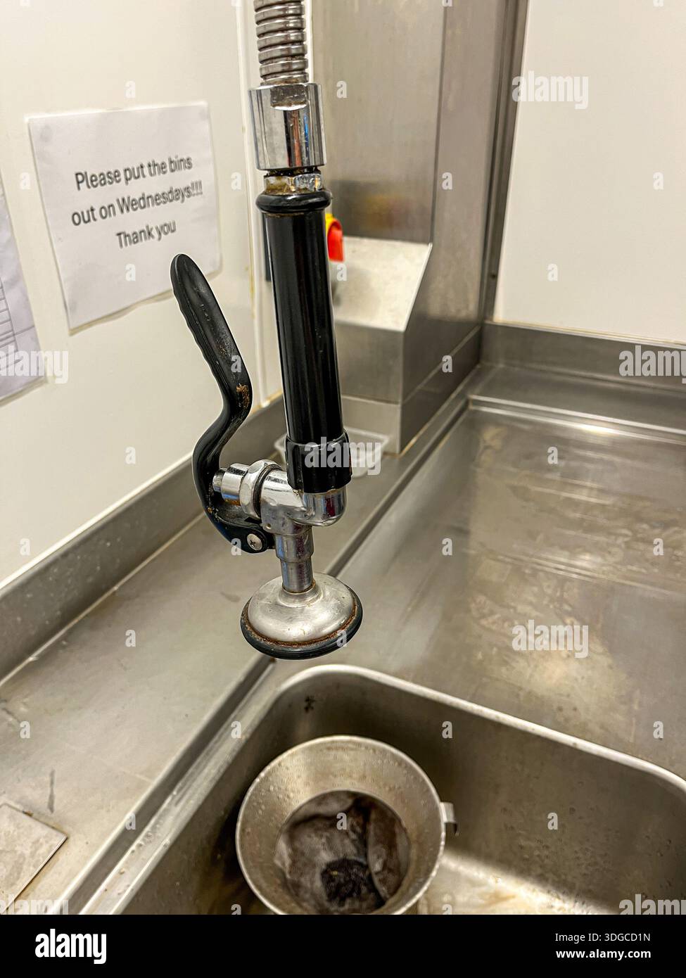 Commercial kitchen pre-rinse spray (tap) with waste disposal notice - Smartphone Captured Stock Image
