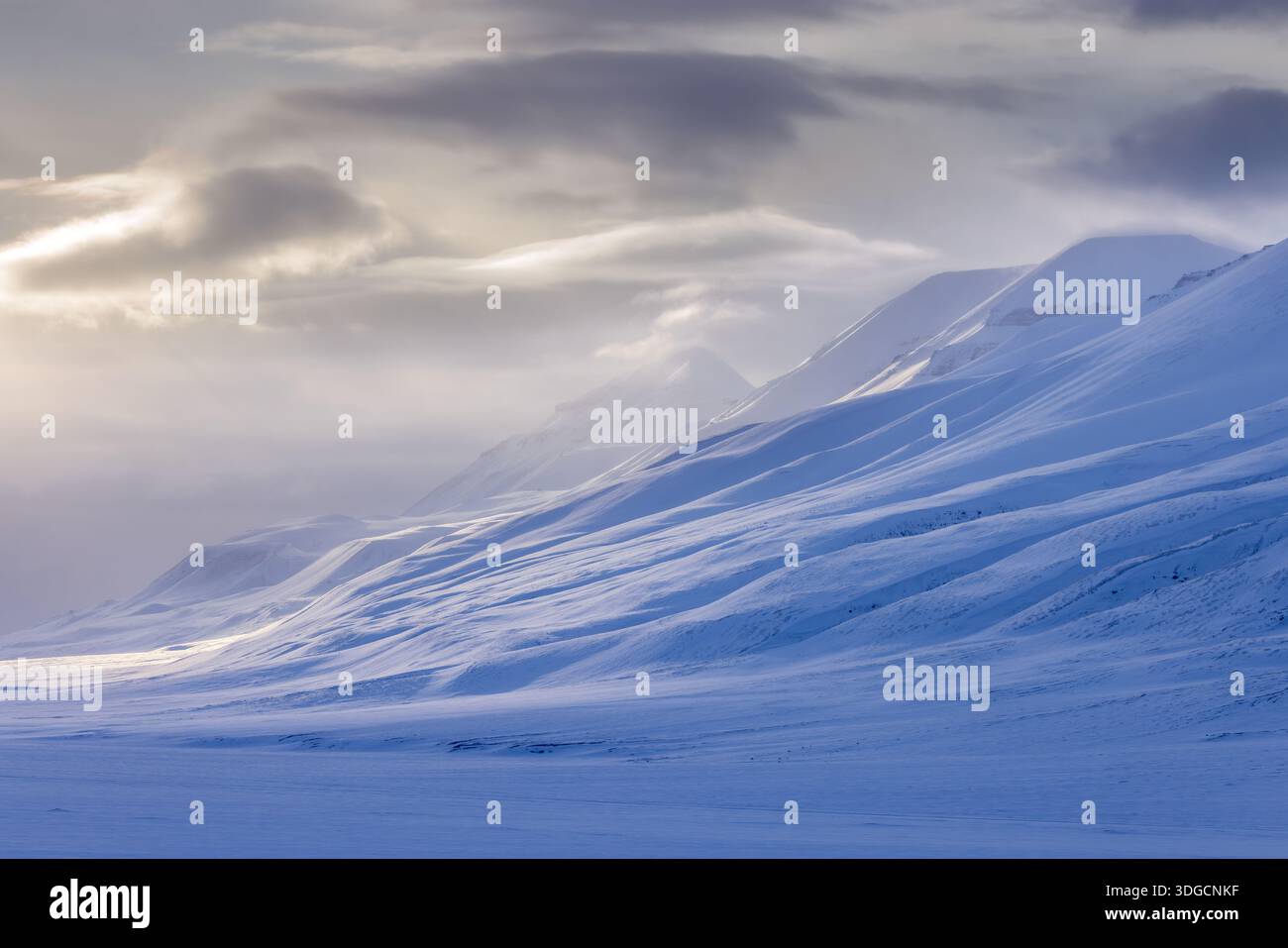 Snow covered mountain peaks along Adventdalen / Advent Valley near Longyearbyen at sunset in spring, Spitsbergen / Svalbard, Norway Stock Photo
