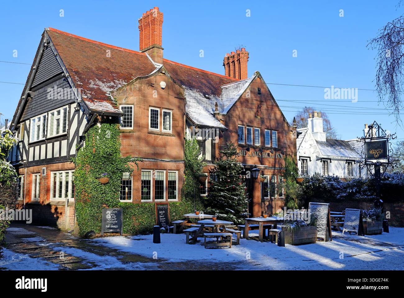The Rams Head public house in the village of Grappenhall near Warrington,Cheshire, photographed in winter with snow on the ground and a Christmas tree Stock Photo