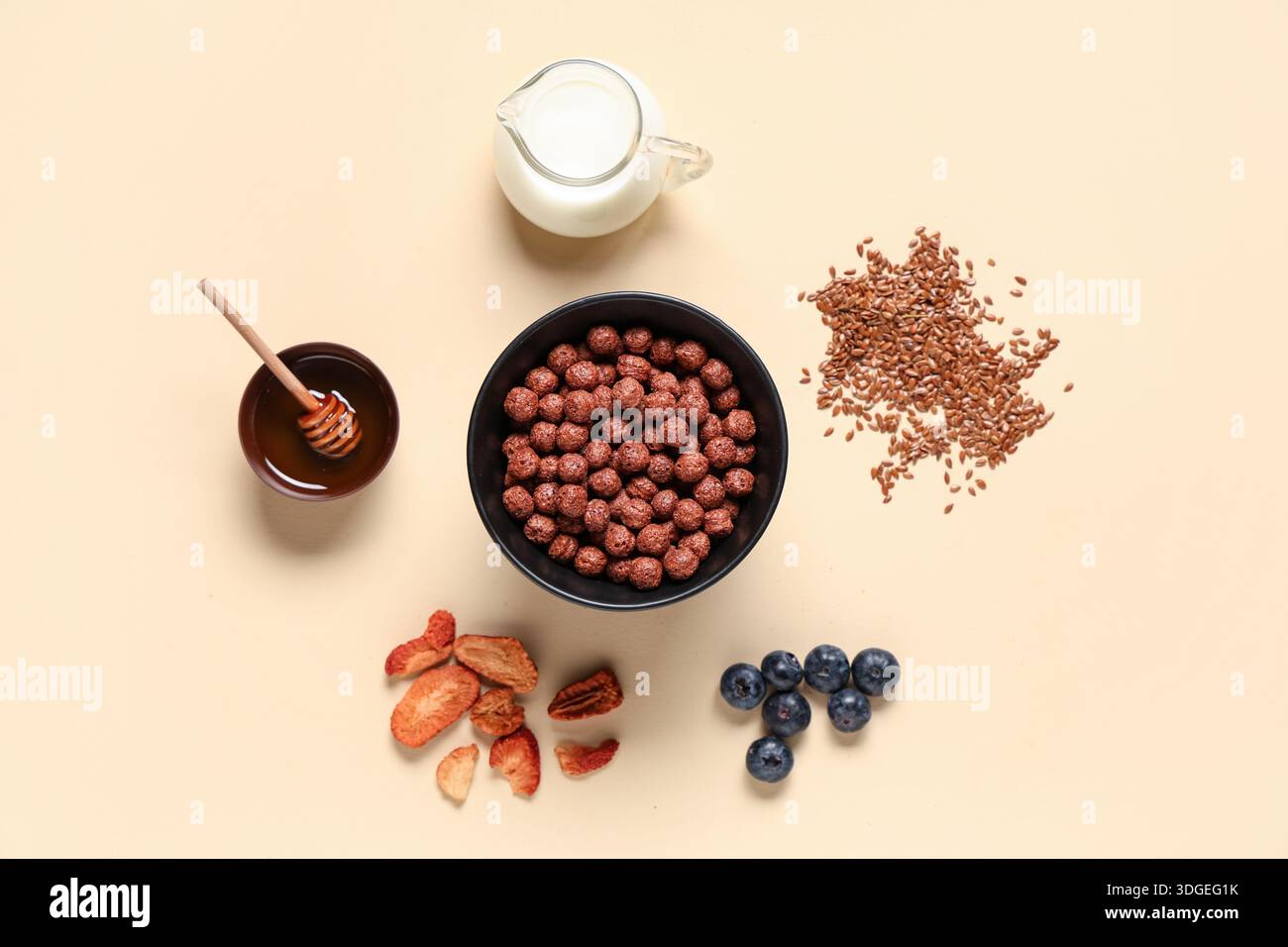 Bowl with cereal breakfast, milk and ingredients on beige background Stock Photo