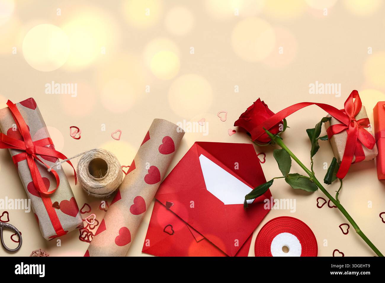 Gifts, wrapping paper, envelopes and rose glower on beige background. Valentine's Day celebration Stock Photo