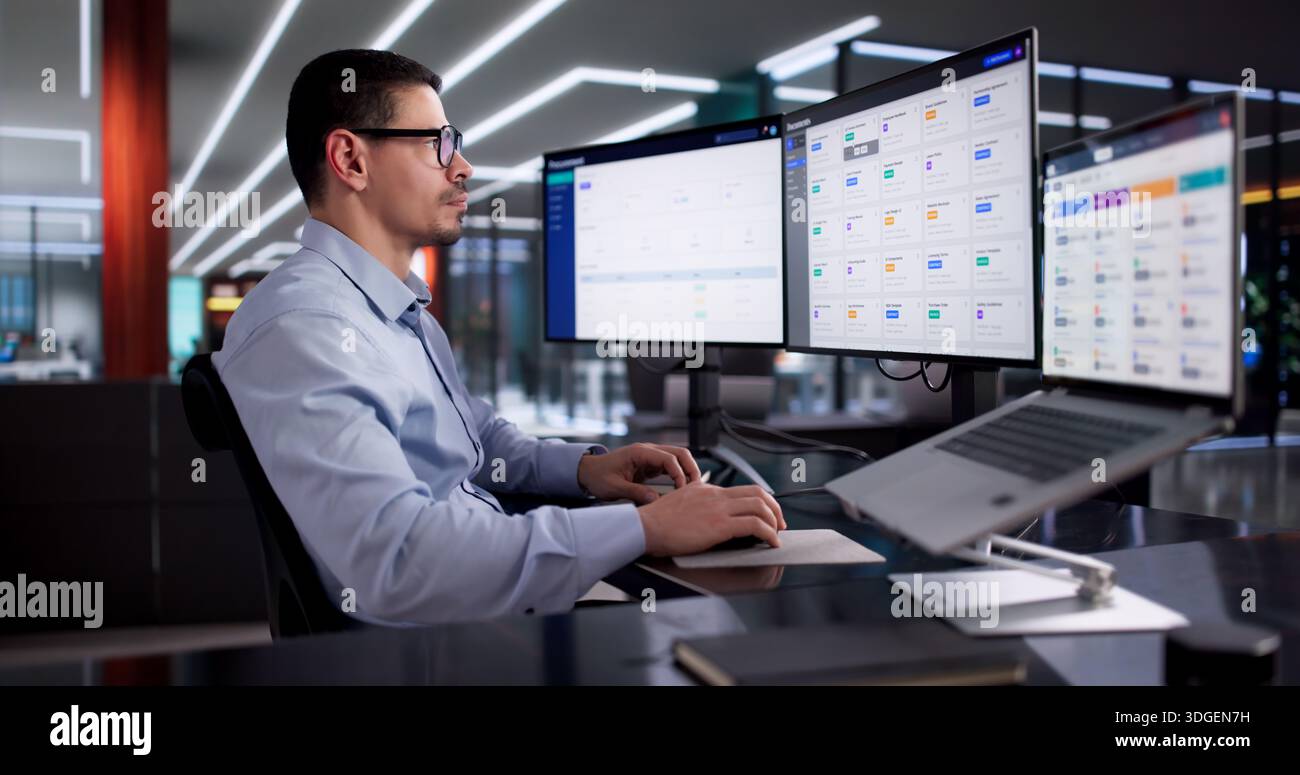 Hispanic Man Utilizes Cloud-based Management Software To Organize Business Documents. Stock Photo