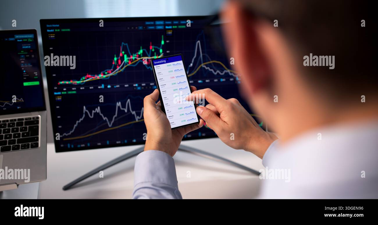 Young Hispanic Businessman Using Mobile App To Trade On Stock Exchange. Stock Photo