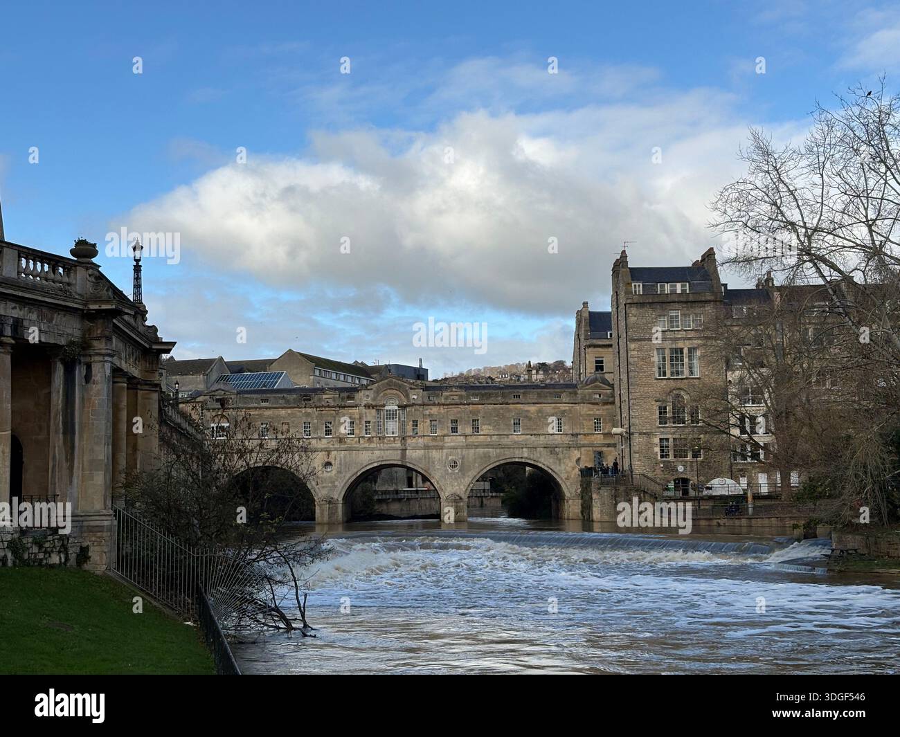 Pulteney Bridge spanning the River Avon in Bath, England, with historic stone buildings and flowing water under a partly cloudy sky. - Smartphone Captured Stock Image