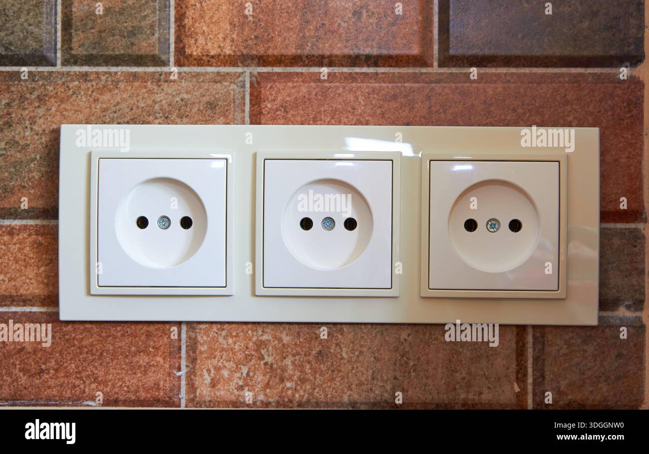 in the kitchen on a ceramic tile triple electrical outlet Stock Photo