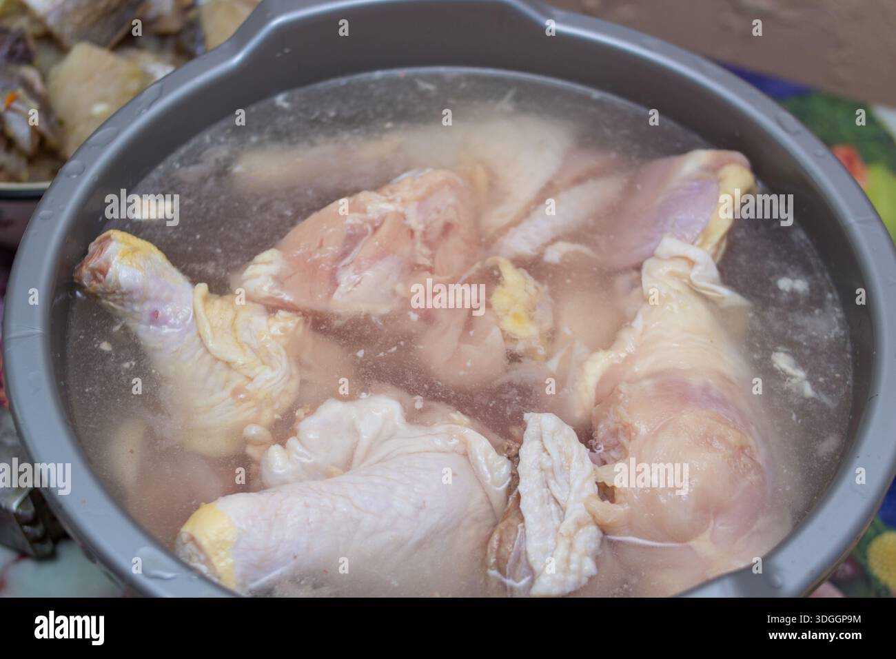 defrost chicken legs in water, cook chicken meat Stock Photo
