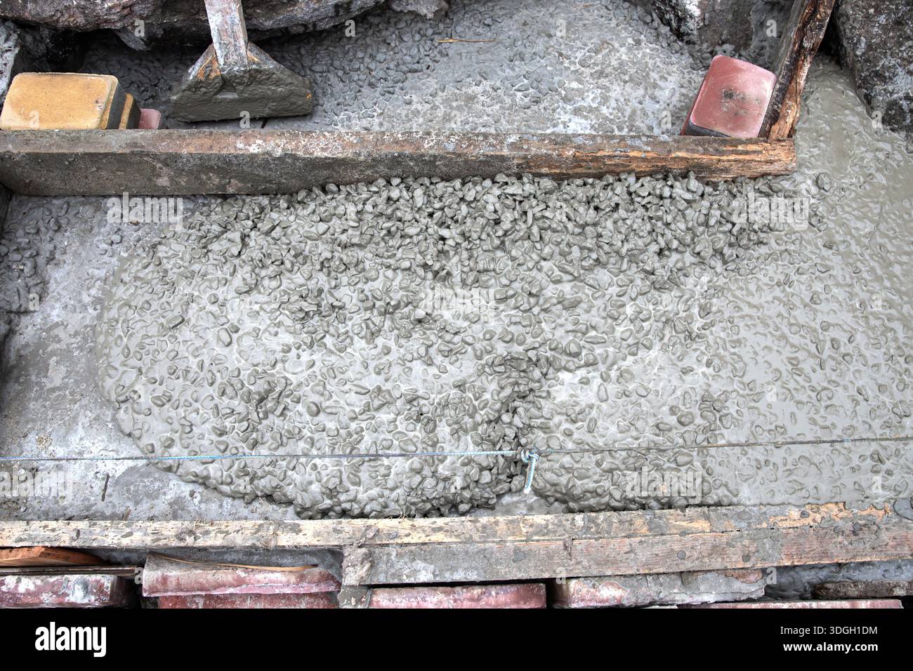 Fresh concrete walkway base with gravel aggregate and leveling line ...
